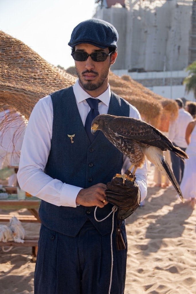 Falcoeiro da Falco Lux com águia de Harris na luva, com uniforme concierge